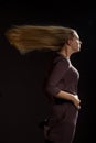 Caucasian white female model portrait. The wind blowing the long blonde hair off on beautiful girl. Woman posing studio shot Royalty Free Stock Photo