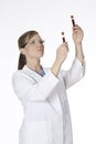 Beautiful woman laboratory technician examining a tube of blood