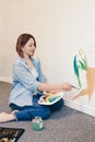 Caucasian woman artist hand painting murals on walls indoor at apartment or studio school with acrylic paints. Lifestyle creative Royalty Free Stock Photo