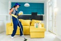 Caucasian woman as a professional cleaner in headphones cleaning floor with mop and listens to music at home.