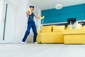 Caucasian woman as a professional cleaner in headphones cleaning floor with mop and listens to music at home.