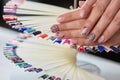 Caucasian woman beige patterned manicure.