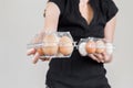 Caucasian woman with black shirt holding two plastic egg boxes full of chicken eggs Royalty Free Stock Photo