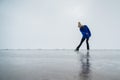 Caucasian woman in a blue sweater is skating on a frozen lake. The figure skater performs the program. Royalty Free Stock Photo