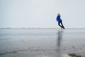 Caucasian woman in a blue sweater is skating on a frozen lake. The figure skater performs the program. Royalty Free Stock Photo