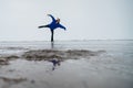 Caucasian woman in a blue sweater is skating on a frozen lake. Figure skater performs a swallow. Royalty Free Stock Photo