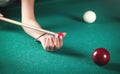 Caucasian woman chalking billiard cue