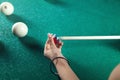 Caucasian woman chalking billiard cue