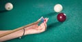 Caucasian woman chalking billiard cue