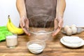 Caucasian woman chef in apron preparing ingredients for making cottage cheese banana muffins cupcakes casserole at home Royalty Free Stock Photo