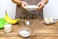 Caucasian woman chef in apron preparing ingredients for making cottage cheese banana muffins cupcakes casserole at home Royalty Free Stock Photo