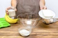 Caucasian woman chef in apron preparing ingredients for making cottage cheese banana muffins cupcakes casserole at home Royalty Free Stock Photo