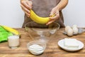 Caucasian woman chef in apron preparing ingredients for making cottage cheese muffins cupcakes casserole at home kitchen Royalty Free Stock Photo