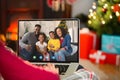 Caucasian woman with christmas decorations having video call with happy african american family Royalty Free Stock Photo