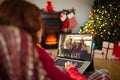 Caucasian woman with christmas decorations having video call with happy caucasian family Royalty Free Stock Photo