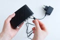 Caucasian woman connect power cable to jack black digital set top box
