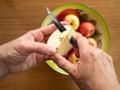 Caucasian Woman Coring an Apple with a Tin Bowl with Apples in t