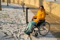 Caucasian woman with disabilities rides on a chair in the park in winter. Girl on a walk in a wheelchair.