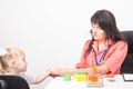 A caucasian woman doctor holds the hand of a little girl patient 3-4 years old in the doctor s office of a pediatrician. Children Royalty Free Stock Photo