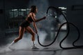 Caucasian woman doing exercise with ropes. Circuit training in the gym. Royalty Free Stock Photo