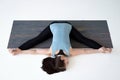 Caucasian woman doing yoga splits upavistha konasana on fitness mat.