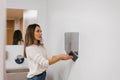 Caucasian woman dries her hands with hot water using a dryer