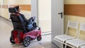 Caucasian woman in electric wheelchair in hospital corridor. Royalty Free Stock Photo