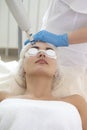 Laser Procedures Ideas. Caucasian Woman Getting Cosmetology Laser Facial Beauty Treatment While Removing Pigmentation in Clinic Royalty Free Stock Photo