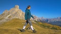 Caucasian woman goes hiking in the picturesque Dolomites on sunny day in fall