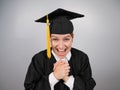 Caucasian woman in graduate gown dreamily holds her hands on her chest. Royalty Free Stock Photo