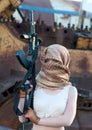 Caucasian woman with a gun in the Arab scarf Royalty Free Stock Photo