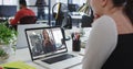 Caucasian woman having a image call with female office colleague on laptop at office