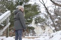 Caucasian woman with her Alaskan malamute playing in the snow Royalty Free Stock Photo