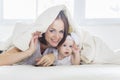 Caucasian woman and her baby under a blanket Royalty Free Stock Photo