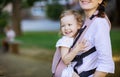 Caucasian woman and her daughter in baby carrier in park Royalty Free Stock Photo
