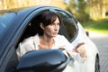 Caucasian  Woman in her 30s sitting in a car, pointing with her finger Royalty Free Stock Photo