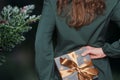 Caucasian woman hiding gift box with golden ribbon behind her back Royalty Free Stock Photo