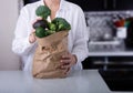 Caucasian Woman Holding Brownpaper Bag Full of Green Vegetables. Royalty Free Stock Photo