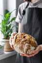 caucasian woman holding fresh bread from the oven, baking homemade bread Royalty Free Stock Photo