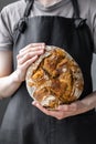 caucasian woman holding fresh bread from the oven, baking homemade bread Royalty Free Stock Photo