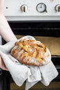 caucasian woman holding fresh bread from the oven, baking homemade bread Royalty Free Stock Photo