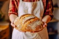 Caucasian woman holding fresh bread from the oven, baking homemade bread. Close up Royalty Free Stock Photo