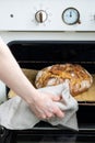 caucasian woman holding fresh bread from the oven, baking homemade bread Royalty Free Stock Photo