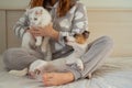 Caucasian woman holding a white fluffy cat and Jack Russell Terrier dog while sitting on the bed. The red-haired girl Royalty Free Stock Photo