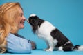 Caucasian woman kissing her puppy japanese chin. Love between dog and owner