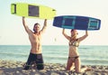 Caucasian woman kitesurfer enjoying summertime on sandy beach with her boyfriend. Royalty Free Stock Photo