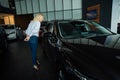 Caucasian woman looking out the car window in a car dealership. Royalty Free Stock Photo