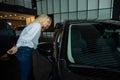 Caucasian woman looking out the car window in a car dealership. Royalty Free Stock Photo