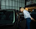 Caucasian woman looking out the car window in a car dealership. Royalty Free Stock Photo