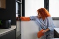 Caucasian woman looking into the oven while cooking cookies. Royalty Free Stock Photo